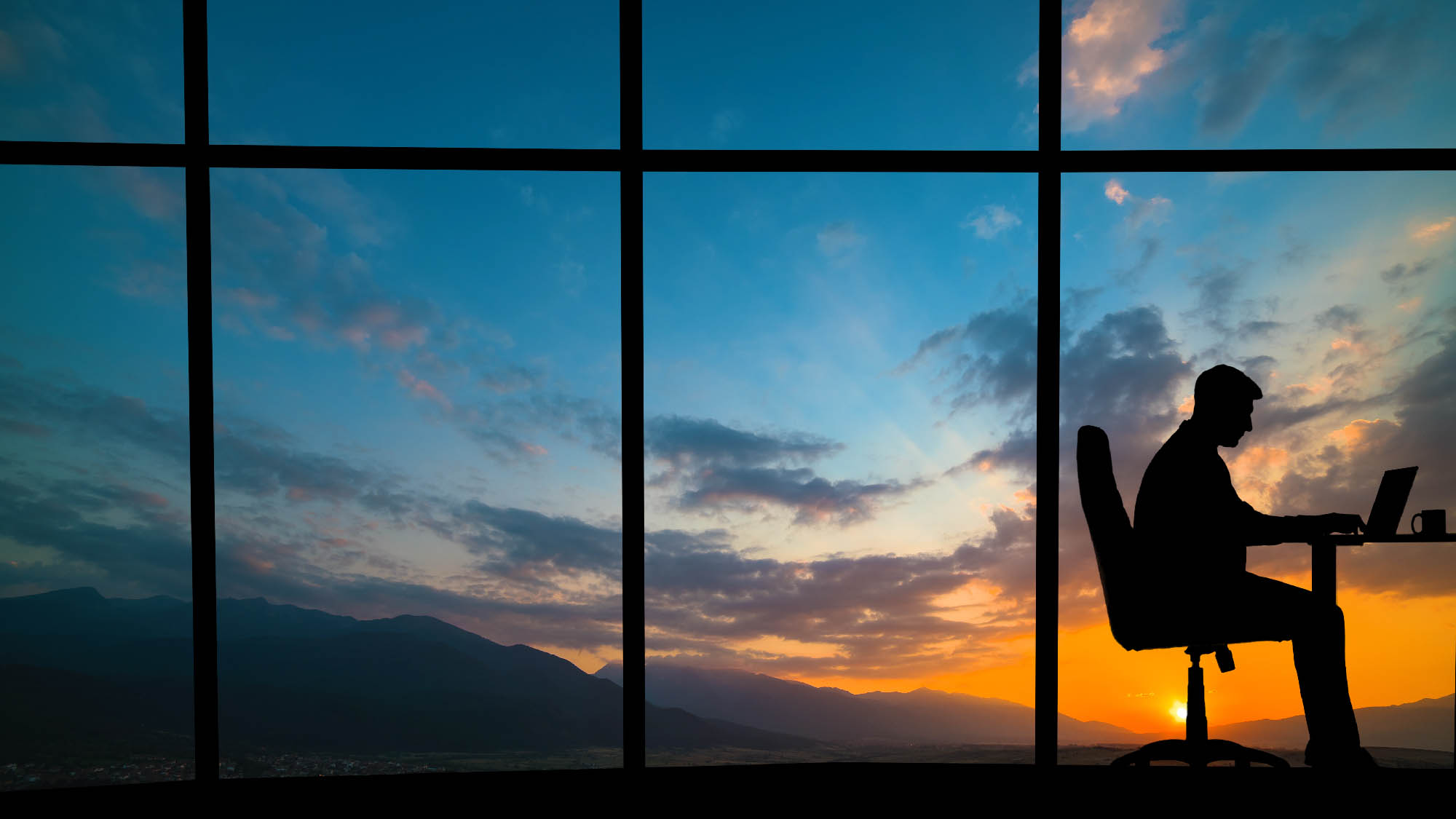 A silhouette of a person in front of a window
