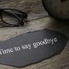 A black paper with white text on it next to a clock and glasses