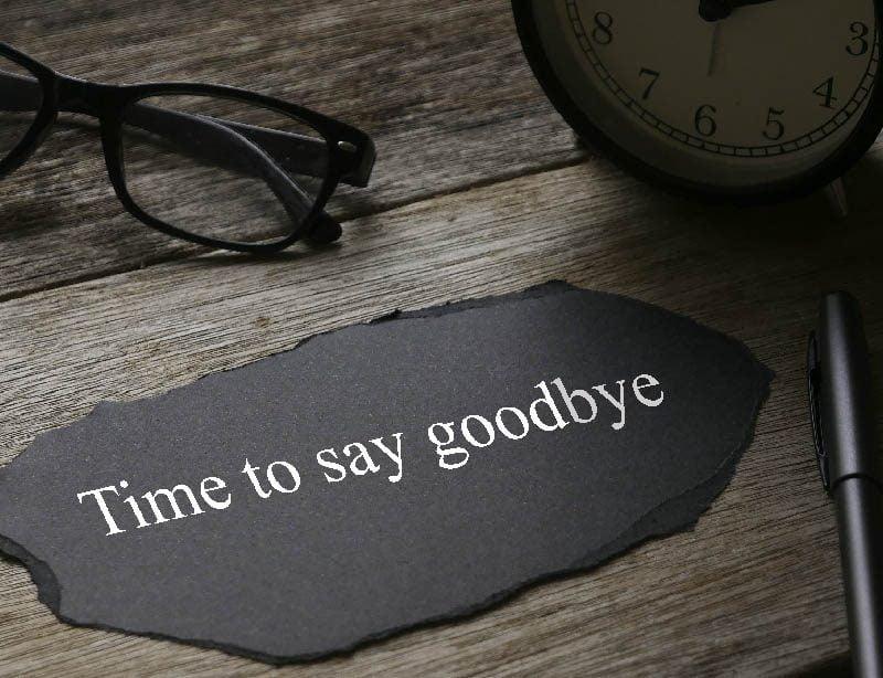 A black paper with white text on it next to a clock and glasses
